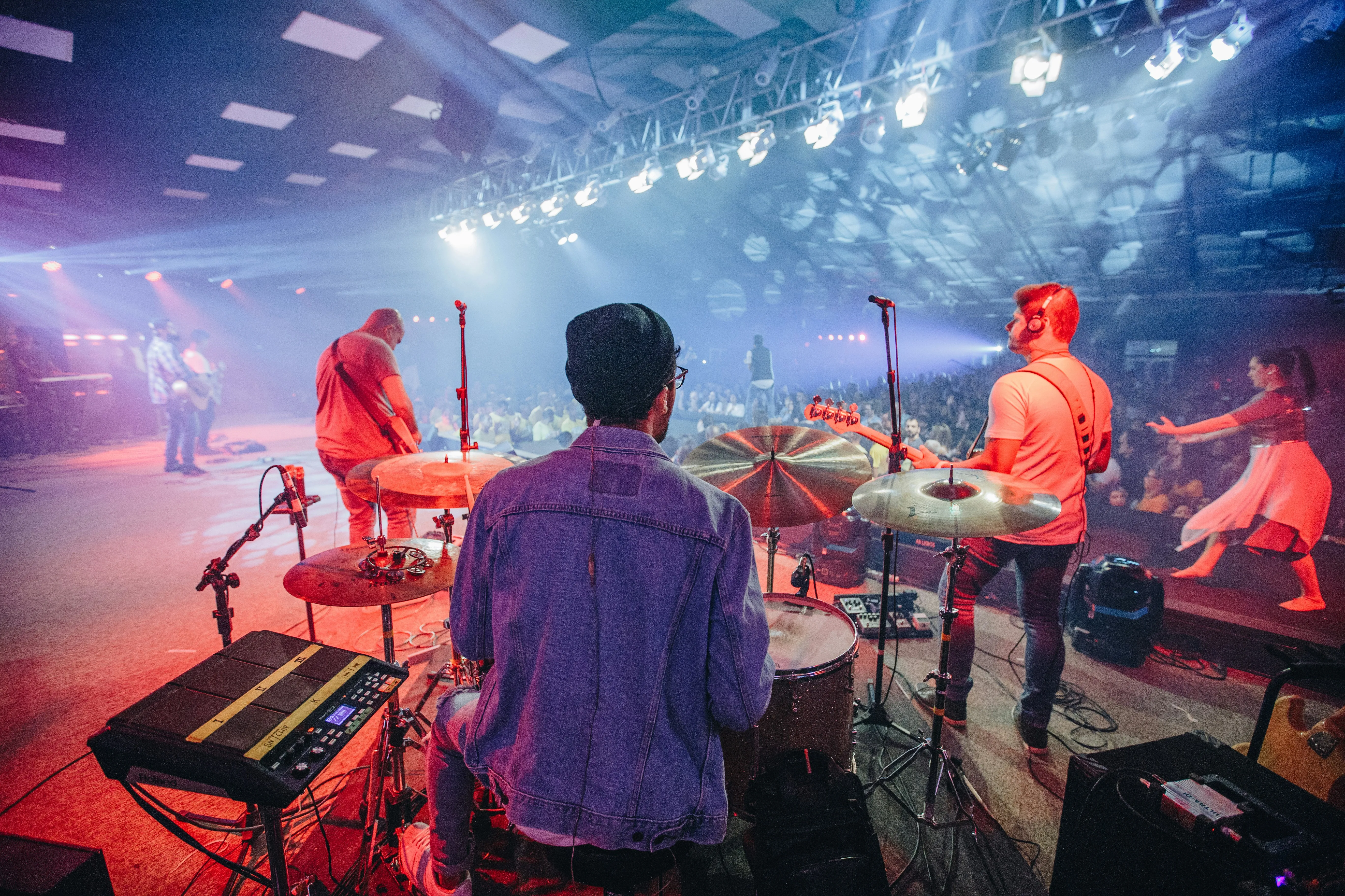 A congregation with hands raised in worship — the response you're building toward, one song at a time