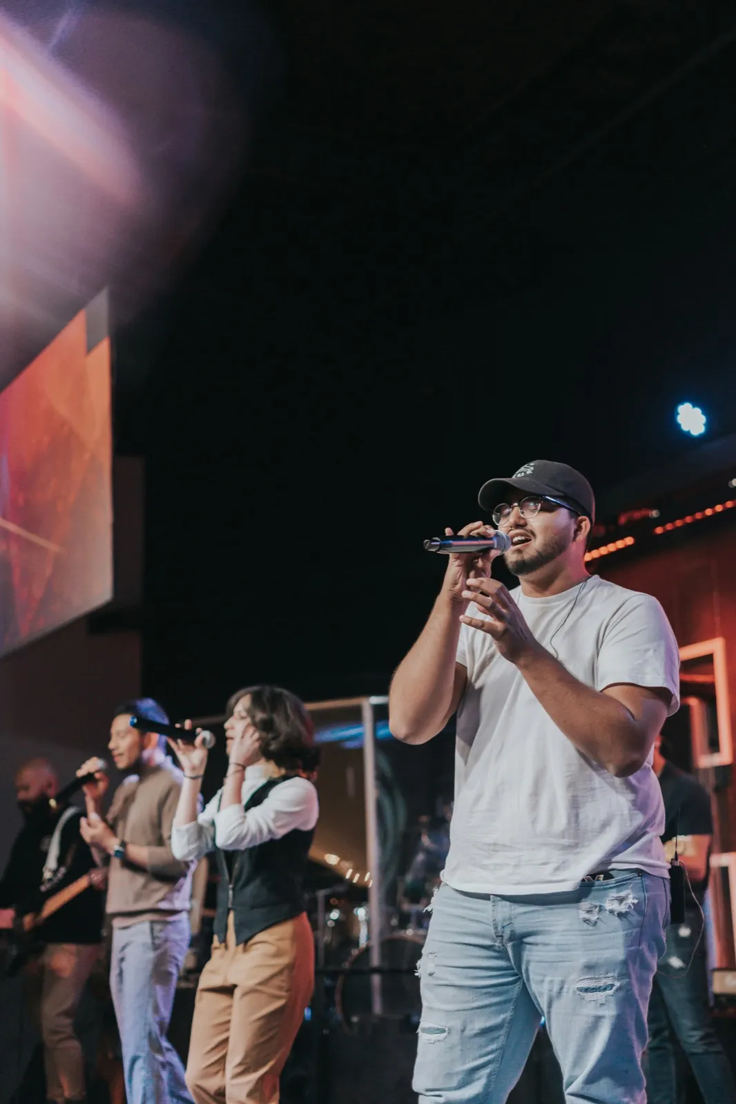 Worship team singing together on stage during a church service